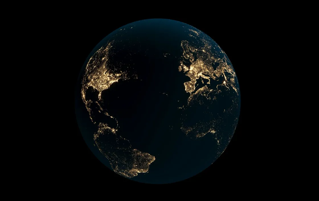 Earth at night with city lights across the Americas, Europe, and Africa, symbolizing global remote and hybrid work connections.