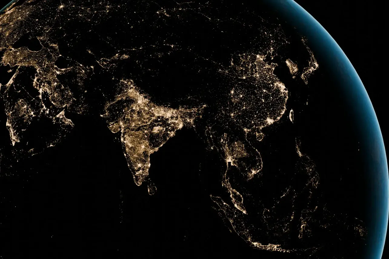 Asia and the Pacific seen at night from space, with city lights across India, Southeast Asia, Japan, and Australia symbolizing connected hybrid work.